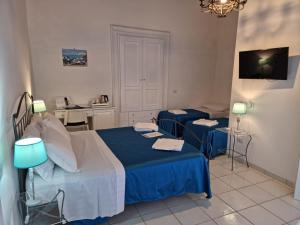 a bedroom with a bed and two blue chairs at Residenza d'epoca Olimpia in Santa Maria di Castellabate