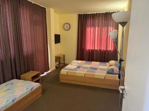 a hotel room with two beds and a window at Петкови Лозенец in Lozenets