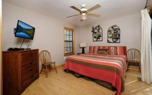 ガトリンバーグにあるSugar Hollowのベッドと天井扇風機のある寝室