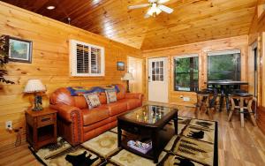 a living room with a leather couch and a table at Dogwood Acres in Pigeon Forge +11 photos