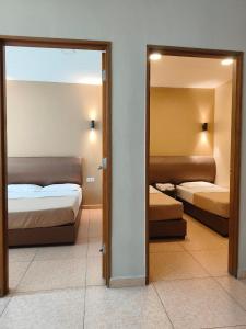 a hotel room with two beds and a mirror at The Pines Hotel in Tanah Rata +5 photos