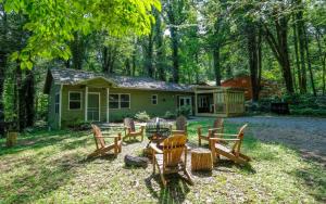 un groupe de chaises et de tables devant une maison dans l'établissement Red Bud Cottage, à Gatlinburg