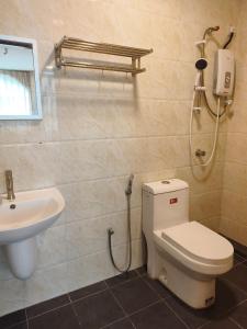 a bathroom with a toilet and a sink at The Pines Hotel in Tanah Rata