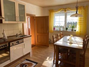 a kitchen with a table and a dining room at FeWo Auszeit Andreas Schreiner in Arrach