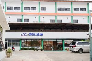 Un edificio con una camioneta estacionada enfrente. en SANS Stay Manlie Hotel & Residence, en Bengkulu