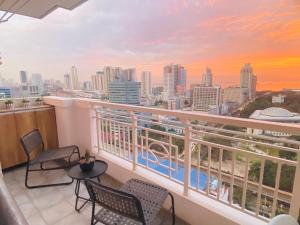a balcony with chairs and a view of the city at Angel's Place Torre De Manila, Cozy 1BR Condo, Sunset View Near all Attractions in Manila