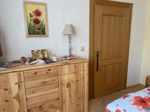 a bedroom with a wooden dresser and a bed at FeWo Auszeit Andreas Schreiner in Arrach