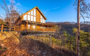 een boomhut op een heuvel met de zon die schijnt bij Like a Comet in Sevierville