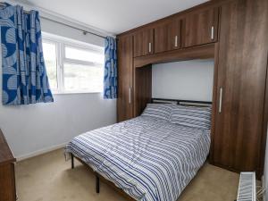 Un dormitorio pequeño con una cama y una ventana. en Beachcombers, 13 Chesil House, en Bridport