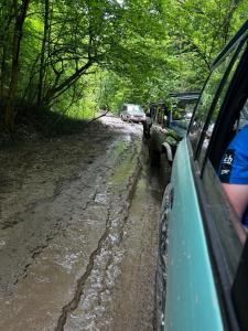 un'auto che percorre una strada fangosa con altre auto parcheggiate di Vital House a Kazimierz Dolny