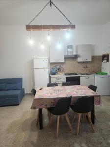 Una cocina con una mesa y sillas en una habitación. en Villa Malese, en Porto Cesareo