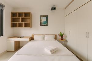 a small bedroom with a bed and a desk at Boho Apartment 81 - Ton That Thiep in Hanoi