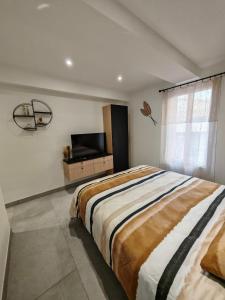 une chambre avec un grand lit et une télévision à écran plat dans l'établissement Maison familiale avec Jacuzzi, à Portiragnes 16 autres photos