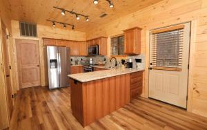 a kitchen with wooden cabinets and a refrigerator at Hot tub and game room! - Black Bear Crossing in Gatlinburg
