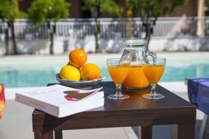 una mesa con dos vasos de zumo de naranja y un tazón de limones en Villa Venere Sicily, en Piedimonte Etneo