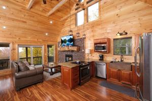 eine Küche und ein Wohnzimmer in einer Blockhütte in der Unterkunft Swept Away in Gatlinburg + 26 Fotos