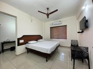 a bedroom with a bed and a television in it at Sri Gavuri Nivas in Trivandrum