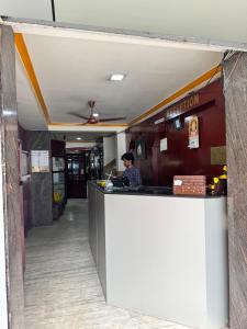 a man standing at a counter in a fast food restaurant at Sri Gavuri Nivas in Trivandrum