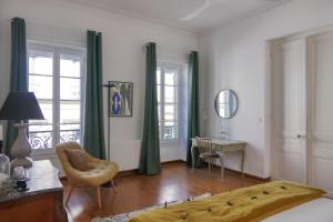 a living room with a bed and a table and chairs at Escale citadine au centre d'Avignon, climatisation, appartement de charme, spacieux et lumineux in Avignon