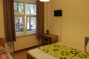 a bedroom with a bed and a desk and a window at Fanni Budapest Guesthouse in Budapest