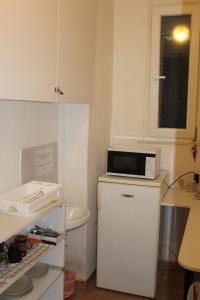 a small kitchen with a microwave on top of a refrigerator at Fanni Budapest Guesthouse in Budapest