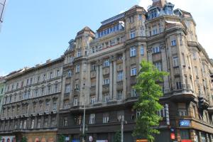 un grand bâtiment avec un arbre en face dans l'établissement Fanni Budapest Guesthouse, à Budapest