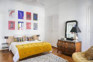 a bedroom with a yellow bed and a mirror at Escale citadine au centre d'Avignon, climatisation, appartement de charme, spacieux et lumineux in Avignon