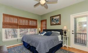 a bedroom with a bed with a ceiling fan and windows at Mountain Acres Retreat - Relax by the wood fireplace and more in Jasper