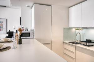 a kitchen with white cabinets and a white counter top at Escale citadine au centre d'Avignon, climatisation, appartement de charme, spacieux et lumineux in Avignon