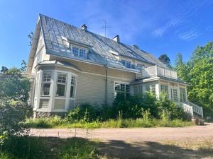 a house with a tin roof on top of it at Charming Villa Apartment in Kauniainen
