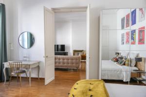 a bedroom with a bed and a desk and a mirror at Escale citadine au centre d'Avignon, climatisation, appartement de charme, spacieux et lumineux in Avignon