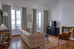a living room with a couch and a chair at Escale citadine au centre d'Avignon, climatisation, appartement de charme, spacieux et lumineux in Avignon