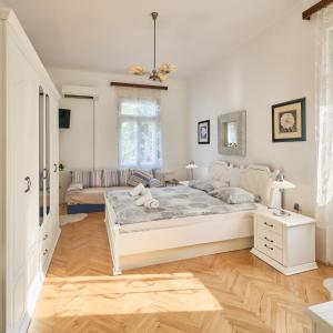 Un dormitorio blanco con una cama y un sofá. en Leona Authentic Beachfront Villa 2BR APT, en Opatija
