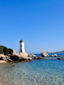 a lighthouse sitting on the rocks near the water at Casa Janas, Palau, Costa Smeralda in Palau