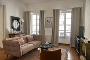 a living room with a couch and a television at Escale citadine au centre d'Avignon, climatisation, appartement de charme, spacieux et lumineux in Avignon