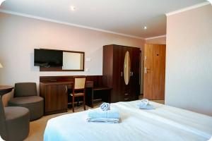 a hotel room with a bed and a desk and a television at Hotel Gracja in Brok