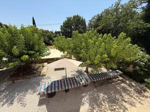 a bench and an umbrella in a park at Gîte Chez Papy in Richerenches