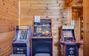 deux jeux d'arcade dans une pièce aux murs en bois dans l'établissement Lakeview Pointe, à Sevierville