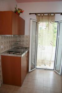een keuken met een deur naar een patio bij Galini Studios in Benitses