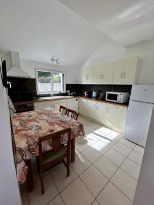 eine Küche mit Tisch und eine Küche mit weißen Schränken in der Unterkunft La Maison Bleue in Saint-Avé + 3 Fotos