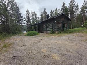 a log cabin in the woods on a dirt road at Kalliorinteen Mökit Suvipirtti in Töysä +9 photos