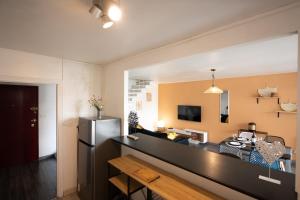 a kitchen and living room with a stainless steel refrigerator at Duplex- T2 Barcelona Pop - Terrasses - Parking - Vue canal in Toulouse