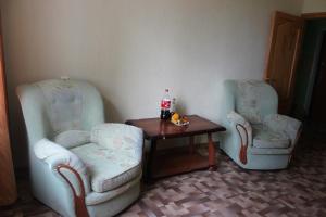 two chairs and a table with a bottle of soda at Apartments on the River in Kamyshin