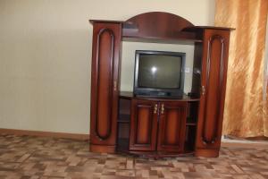 an entertainment center with a tv in a room at Apartments on the River in Kamyshin