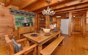 a dining room with a large wooden table in a cabin at Holden On in Pigeon Forge