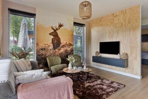 a living room with a deer mural on the wall at Lodge 't Hert - Nieuwe lodge met vrij uitzicht & omheinde tuin in Putten