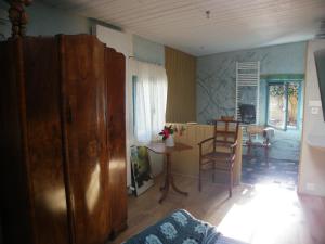 a living room with a table and chairs and a kitchen at les couleurs de l'eau in Plonéour-Lanvern