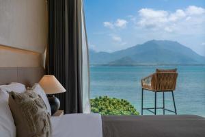 a bedroom with a bed and a view of the ocean at 深圳较场尾东海岸海景民宿 in Dapeng +122 photos