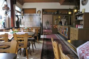 a restaurant with tables and chairs and a kitchen at Hotel Restaurant LAHNHOF in Dausenau