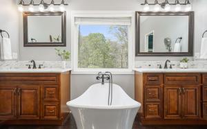 a bathroom with a tub and two sinks and a window at Tranquility Paradise in Sevierville +87 photos